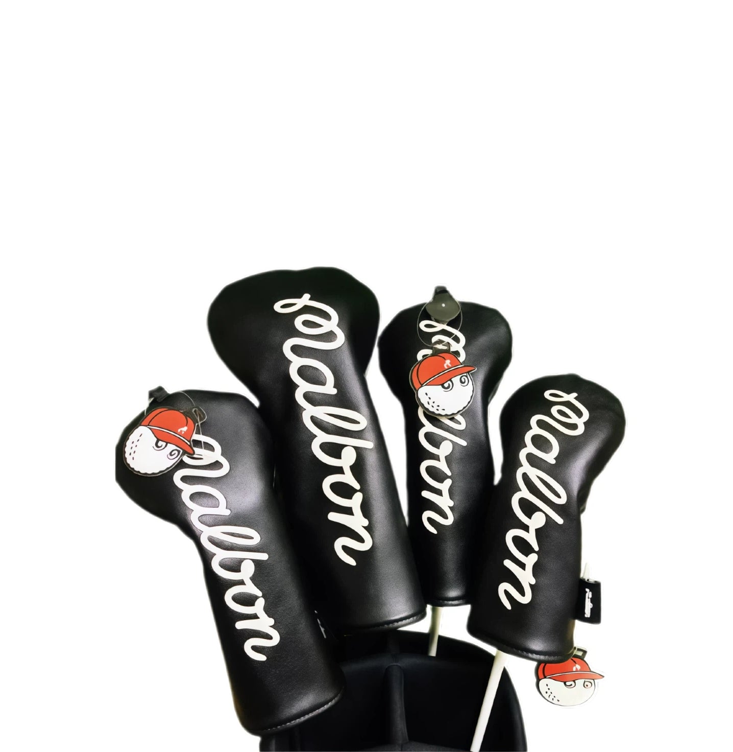 Four black Malbon Golf driver headcovers with white script logo and cartoon ball-and-cap charms on shafts