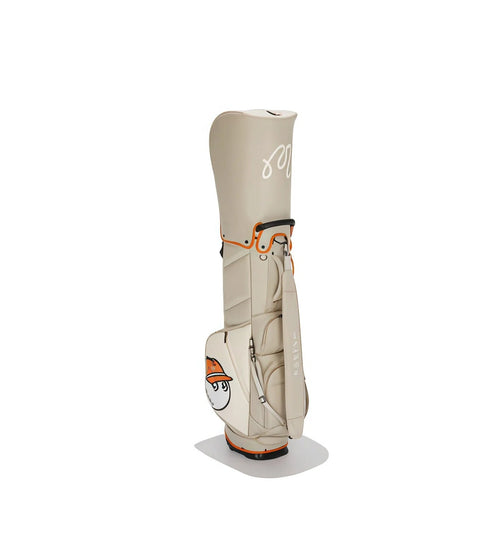 2026 Malbon golf stand bag in beige and orange color scheme, with waterproof material, ample storage space, and a cute cartoon mascot wearing an orange hat, ideal for unisex use on the golf course.