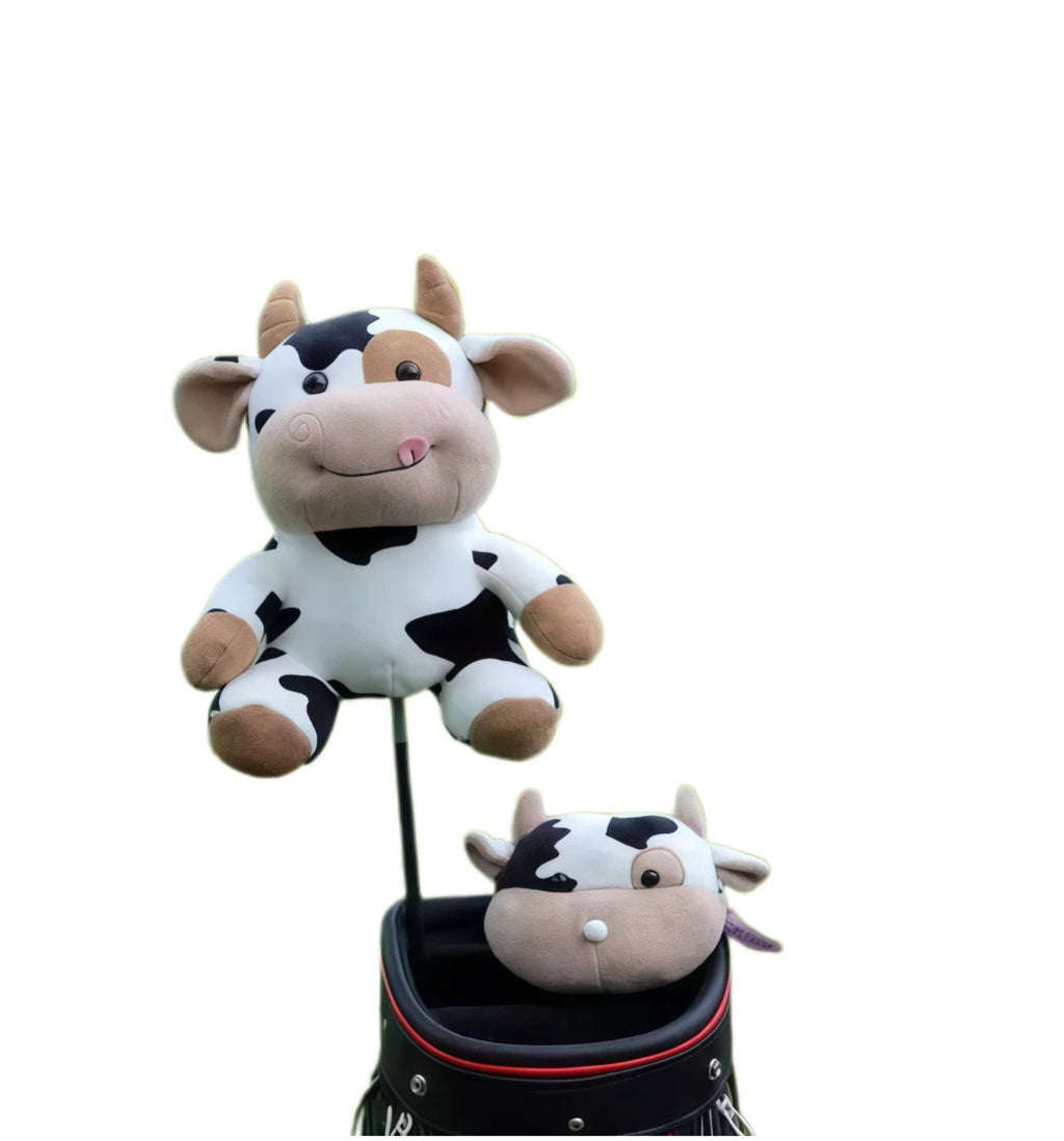 Two cow plush golf headcovers, one on a club shaft, the other resting on a black tour bag rim showing back of head