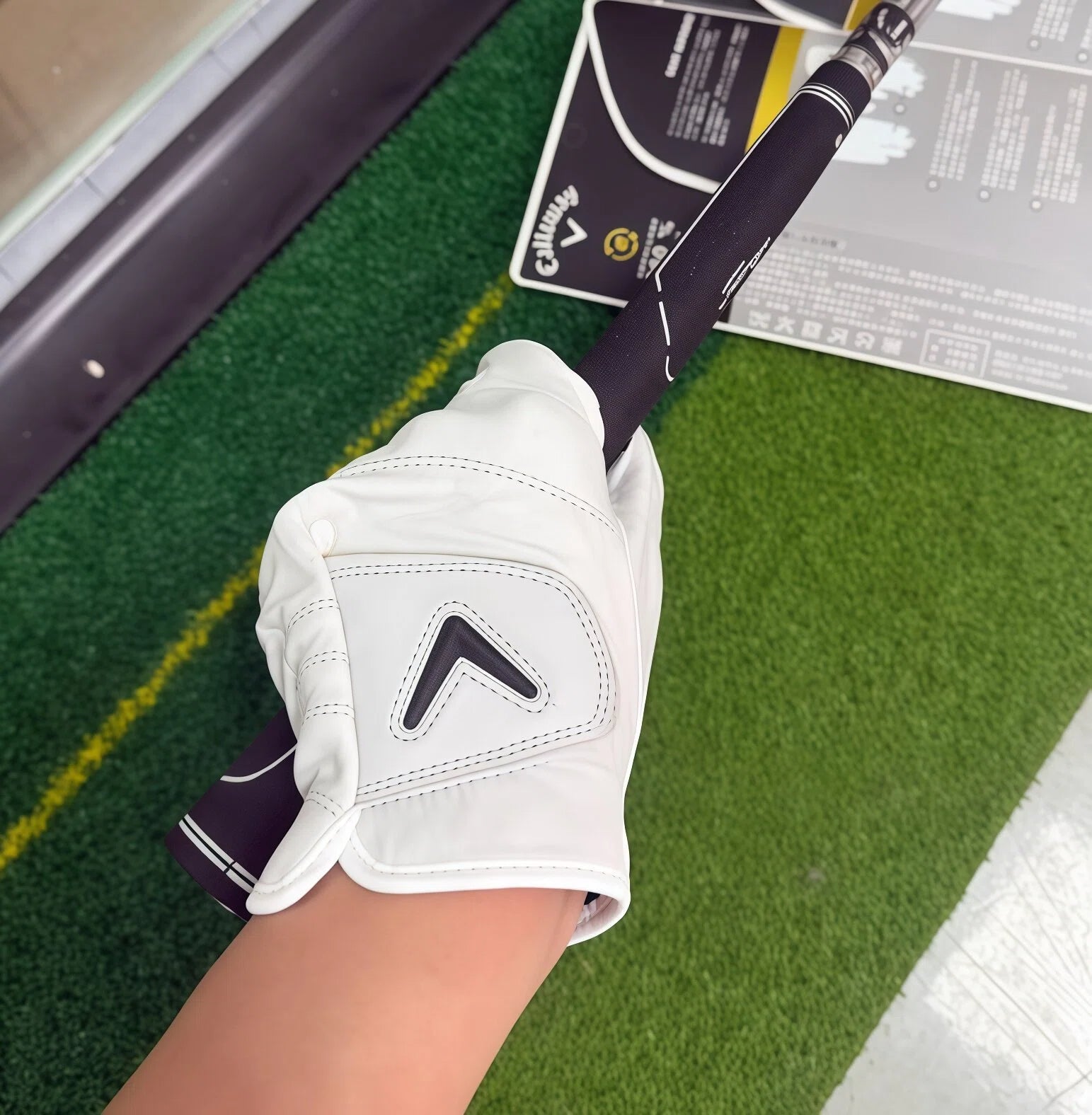 Golfer wearing the Callaway 2025 Tour Authentic left-hand glove gripping a club, demonstrating the glove's second-skin fit and enhanced tactile feedback on the green.