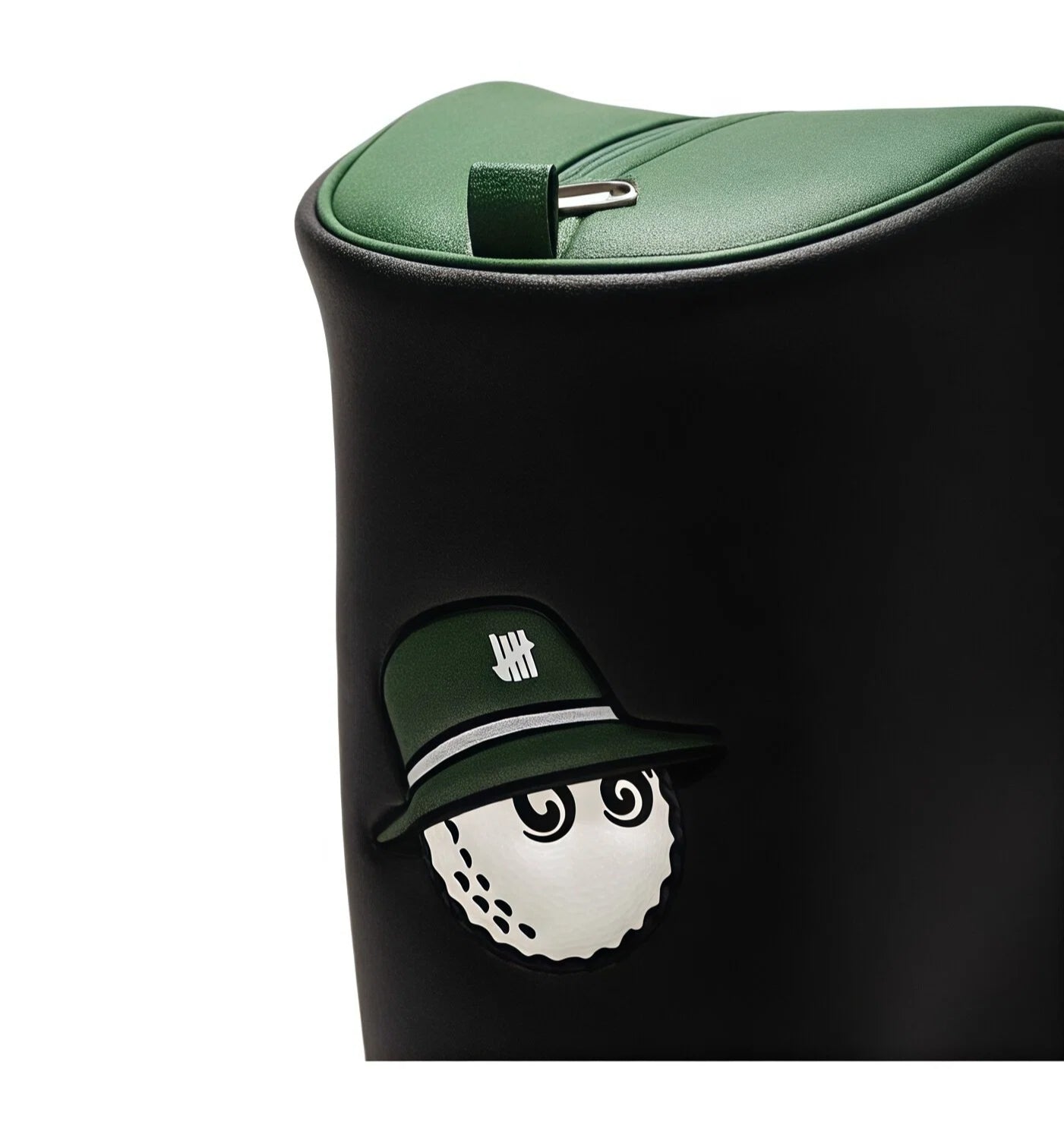 Close-up of Malbon Golf bag’s hood featuring playful golf ball character in green cap with silver stripe, textured PU leather surface, and reinforced zipper pull tab.