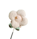 Front view of a cream-colored plush sunflower driver headcover featuring soft fur petals, a light pink center with gold flower emblem, and green leaf accents with brown monogram details.