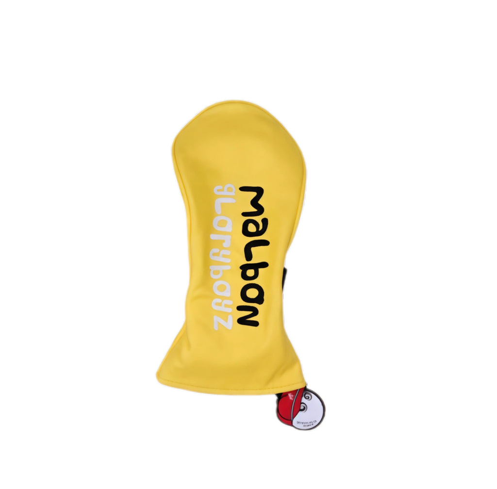 Side angle of vibrant yellow Malbon Gloryboyz driver headcover displaying vertical “Malbon Gloryboyz” lettering in black and white, plus detachable pink-capped magnetic ball charm for easy attachment.