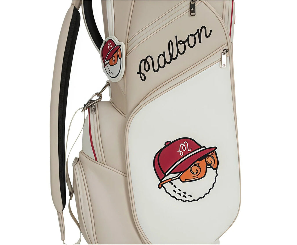 Front close-up of Malbon Golf cart bag featuring playful cartoon mascot wearing a red cap with "M" logo. Includes main compartment zipper and stylish "Malbon" script branding.