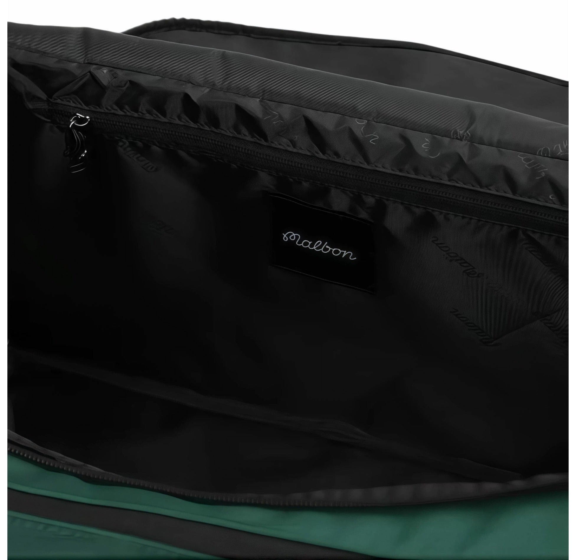 Close-up of the interior of Malbon Golf Performance duffel bag showing black lining with subtle "Malbon" pattern print and embroidered brand label