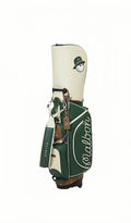 Malbon golf stand bag in green and white colorway, featuring waterproof PU leather construction, large capacity storage, and a stylish design with a cartoon golf ball mascot wearing a green hat, suitable for both men and women golfers.