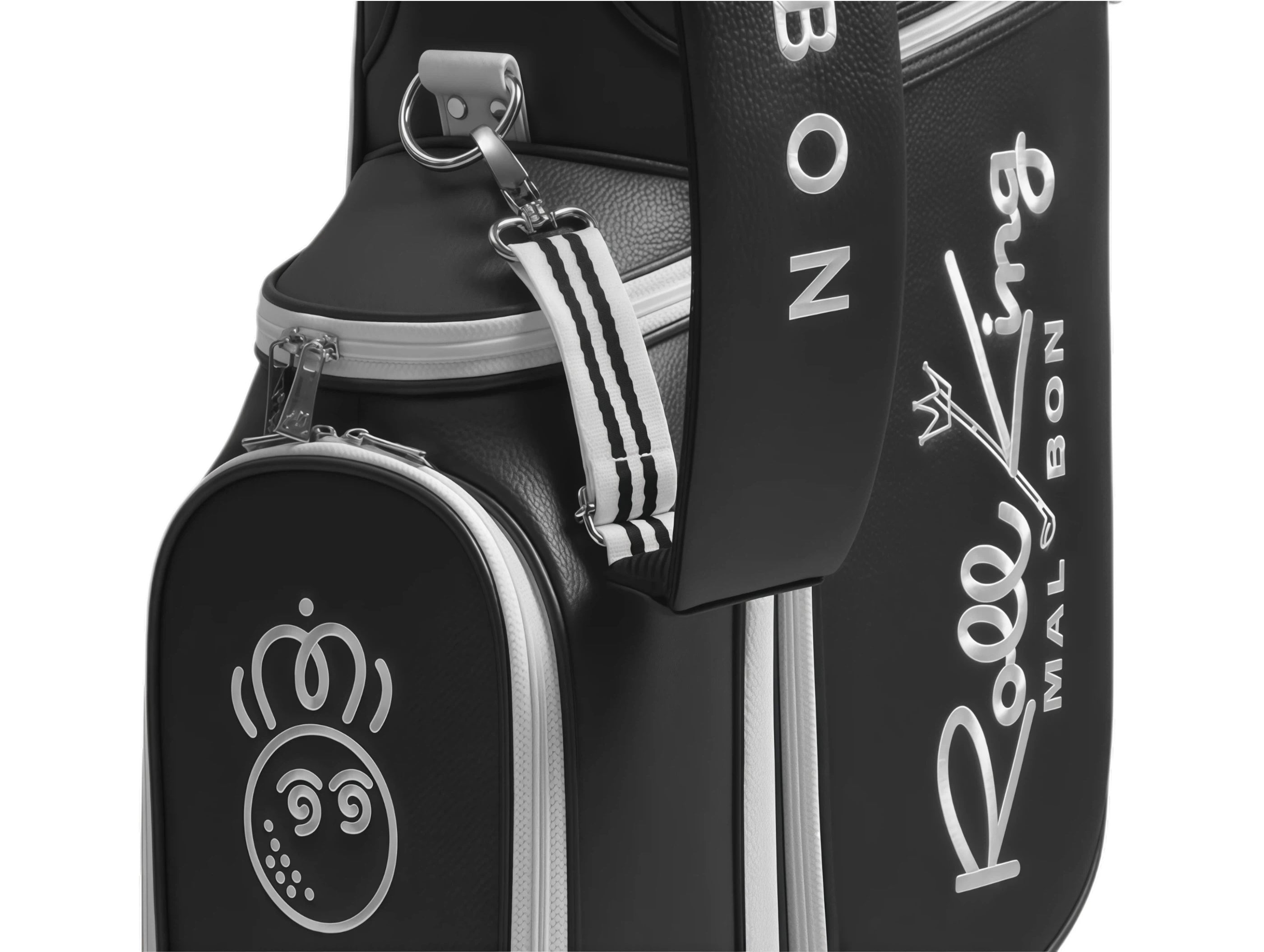 Close-up of Malbon Roo King golf bag side pocket featuring playful cartoon golf ball logo with spiral eyes, silver stitching, and striped carry strap.