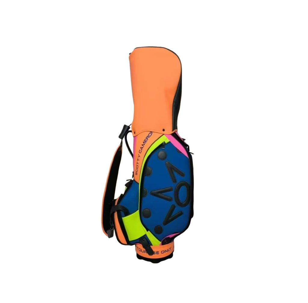 Side profile of the Scotty Cameron 2023 Tour Bag, showcasing the orange "TOUR ONLY" shoulder strap, neon yellow accents, and the "SCOTTY CAMERON" branding along the side.