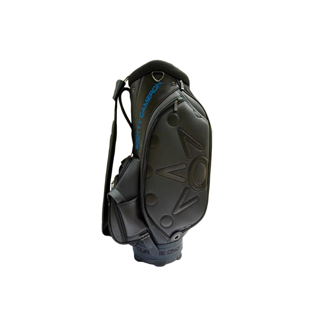 Front view of the Scotty Cameron Backin Black Tour Bag highlighting the large 3D "NOV" lettering, carbon fiber texture details, and blue accent stitching.