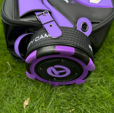 A detailed shot of the bottom of the Scotty Cameron Tour Bag, featuring a rugged, non-slip base with purple accents. The iconic "Circle T" logo is prominently displayed in the center, signifying its premium quality and brand identity.