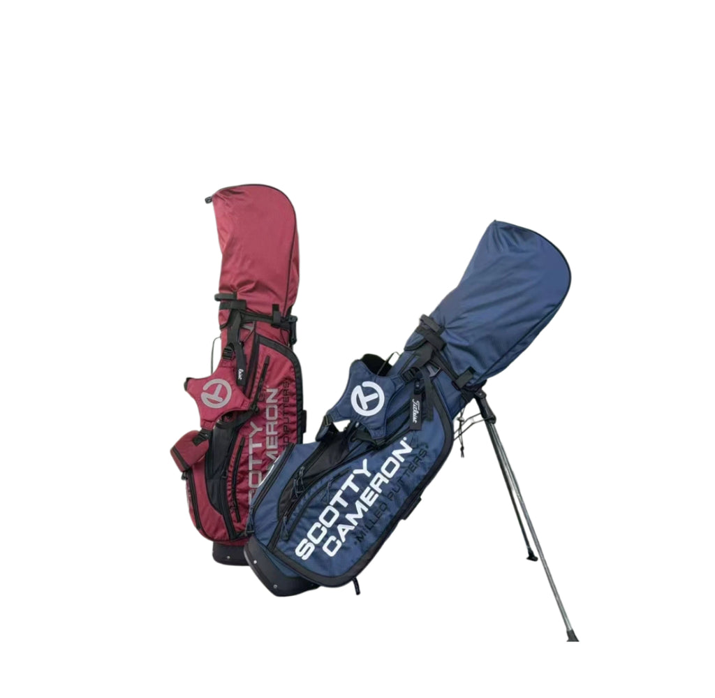 A group shot displaying two Scotty Cameron Pathfinder Mainstay Stand Bags, one in deep red and one in navy blue. Both bags feature the iconic Circle T logo and are shown with their stands deployed.