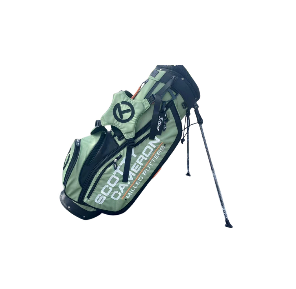 Side profile of the Scotty Cameron Pathfinder Stand Bag in Green, displaying the Titleist tag, multiple storage pockets, and streamlined silhouette with orange trim.