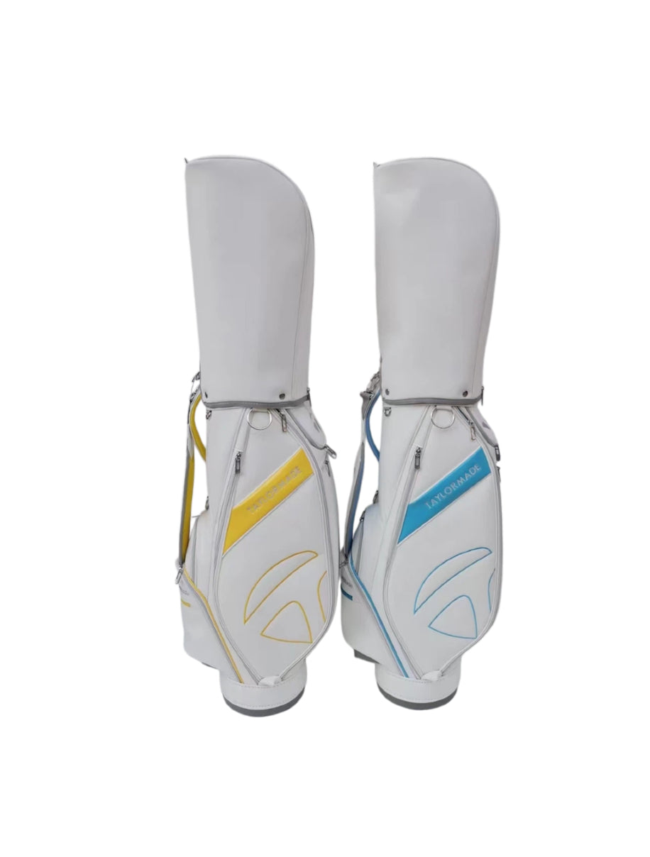 Comparison image showing two TaylorMade Concept One golf cart bags — one in white with yellow accents and one in white with blue accents. Both feature the signature diagonal stripe, embossed logo, and lightweight construction ideal for golfers seeking performance and style.