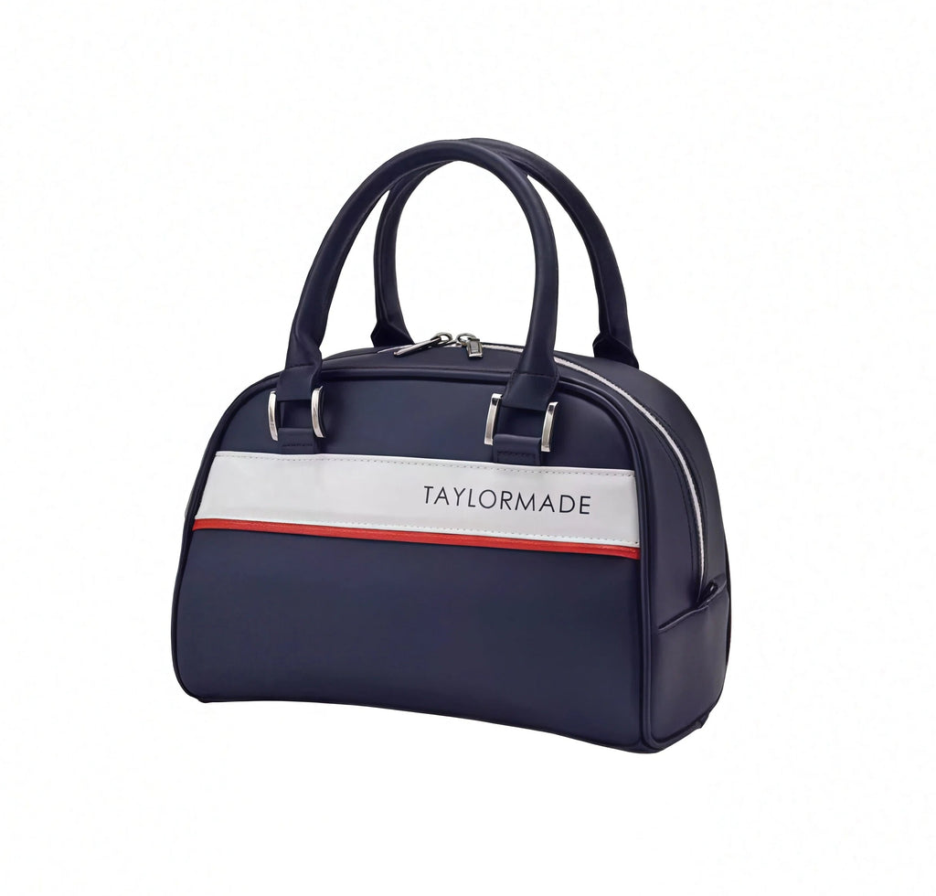 TaylorMade Women’s Golf Tote in navy blue with a bold white and red horizontal stripe across the front. Features "TAYLORMADE" text branding and elegant silver hardware.