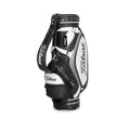 Side view of the Titleist Classic Leather-Look Cart Bag in black and white. Features the "Titleist" script logo, padded shoulder strap, and reinforced base with rubber feet. Sleek and professional design.