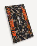 Malbon Tour Divot Camo golf towel in Bark Camo with orange branding, three-quarter studio view
